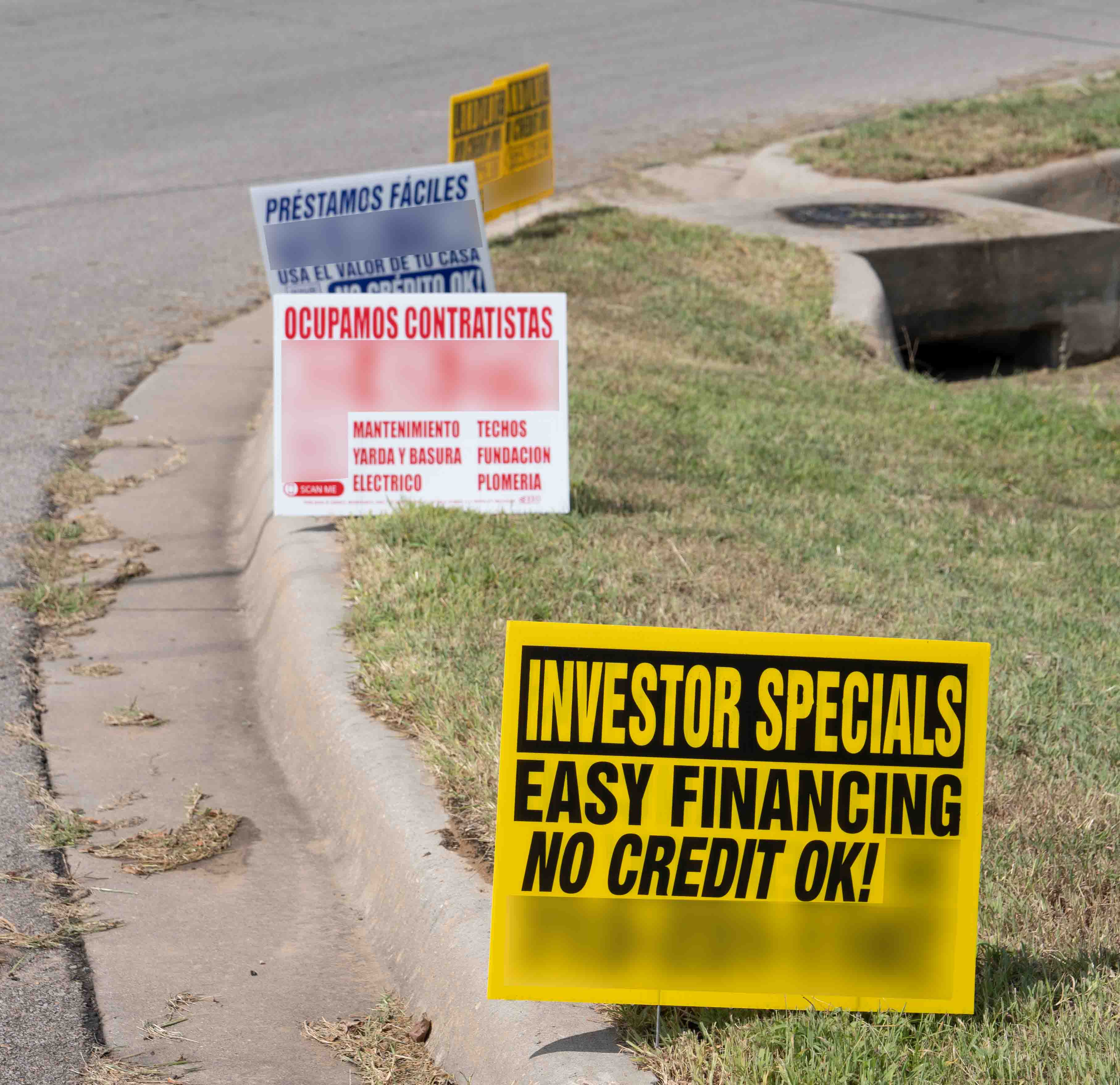 picture of illegally placed for sale signs in right of way near the curb of a street